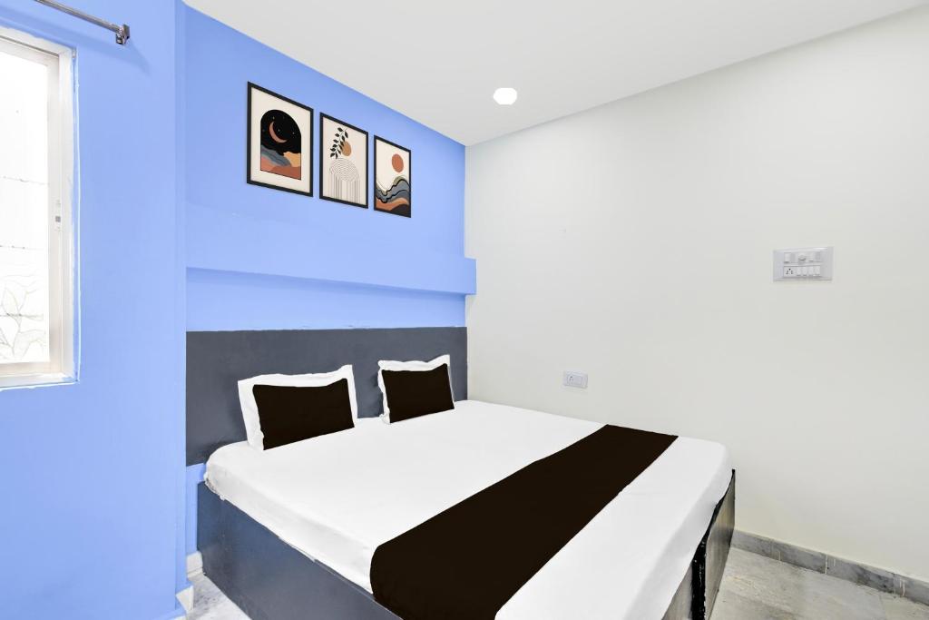 a bedroom with a bed with a blue wall at Hotel O HOLIDAY STAR IN in Hyderabad