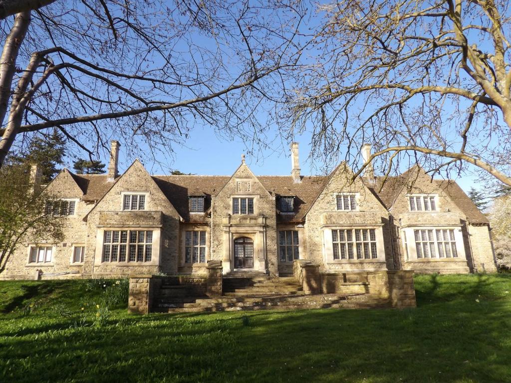 a large stone house with a large yard at Raphael Rooms in Peterborough
