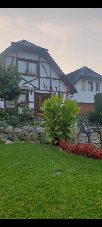 a house with a bench and flowers in a yard at Vermietung auf dem Berg in Bestensee