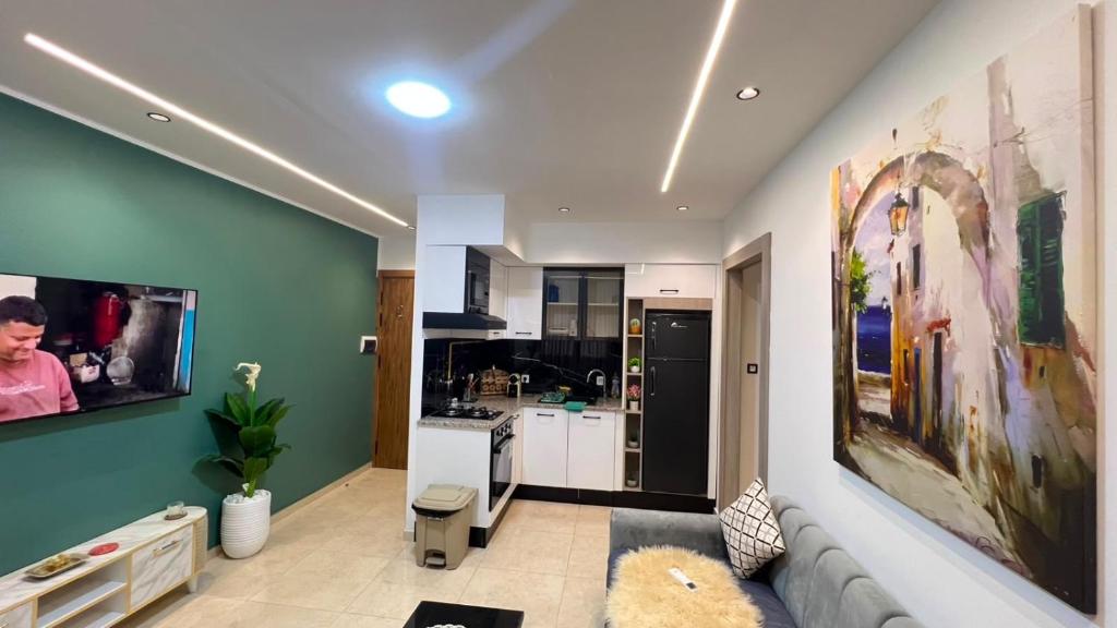 a living room with a couch and a kitchen at Superbe appartement Khezama in La Corniche