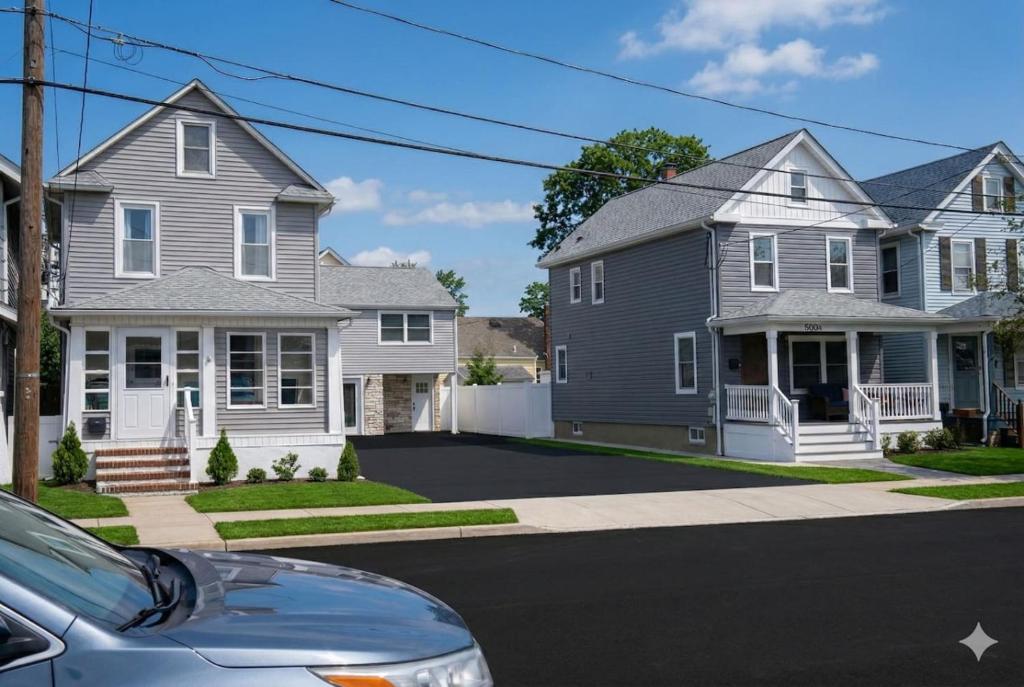 a house with a car parked in a driveway at Bradley Beach Compound in Bradley Beach