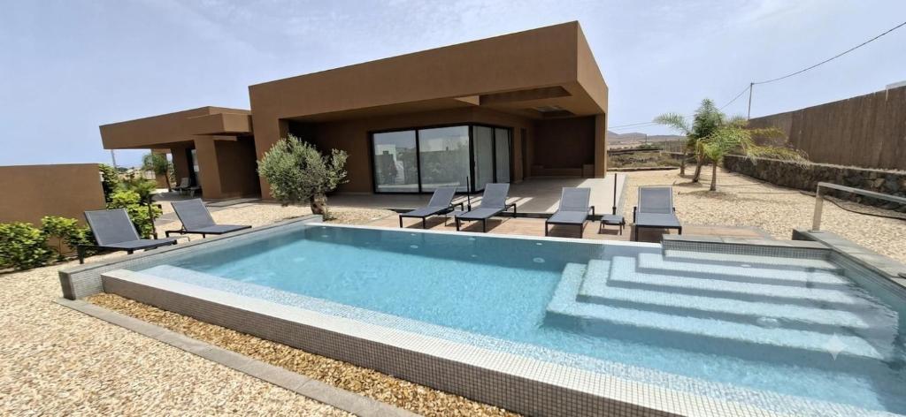 a swimming pool in front of a house at Natural Beatriz Luxury Villa Baby Package Included in Lajares