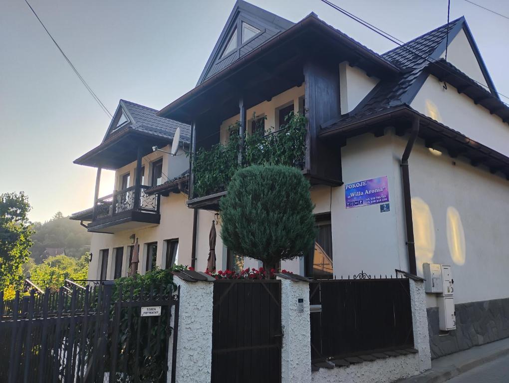 a large house with a black fence in front of it at Willa Aronia in Szczawnica