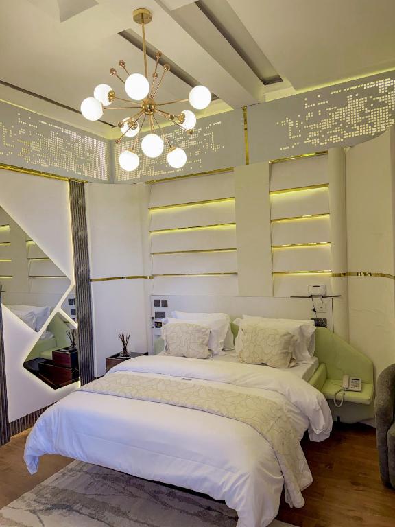 a bedroom with a large bed with a ceiling at IGAWILO RESIDENCE Hotel in Dodoma