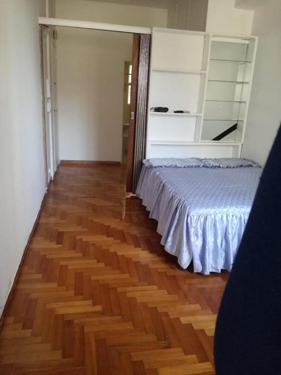 a bedroom with a bed and a wooden floor at Centro Obelisco in Buenos Aires