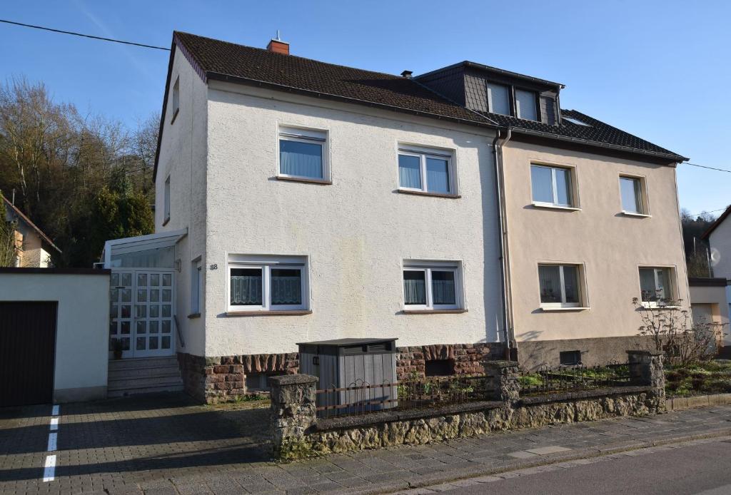 a large white house with a fence in front of it at Ferienwohnung Barthel in Merzig