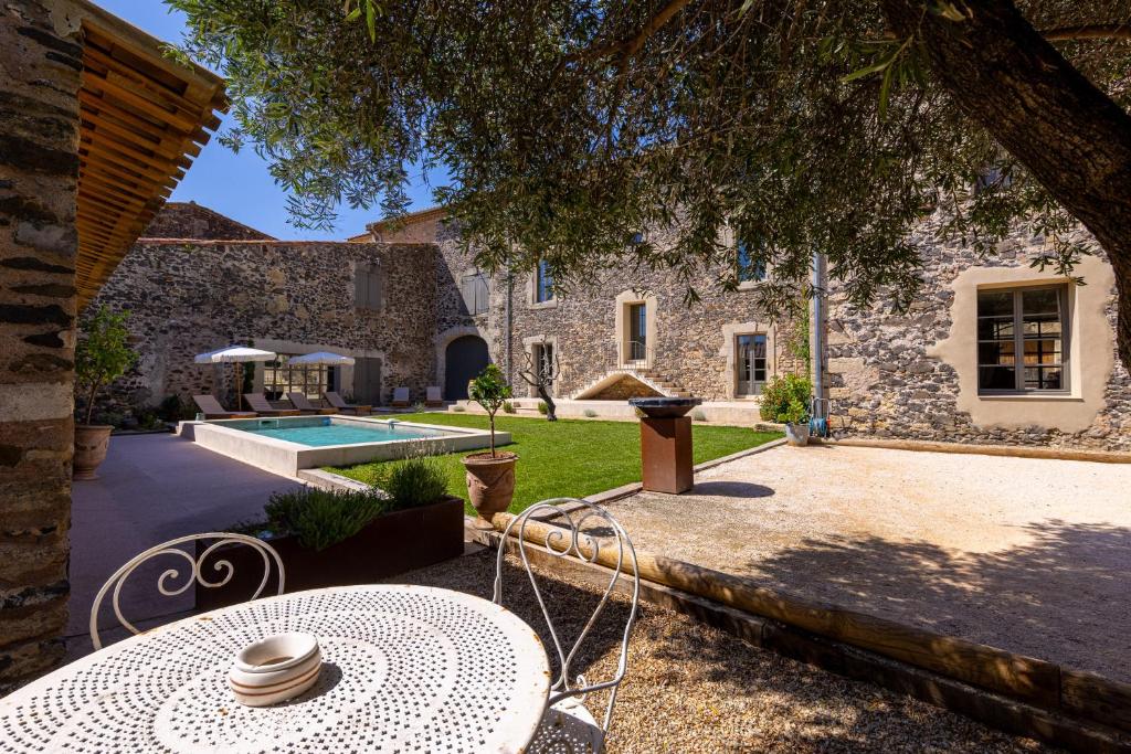 an external view of a stone house with a patio and a pool at Domaine Croix-Maro in Caux