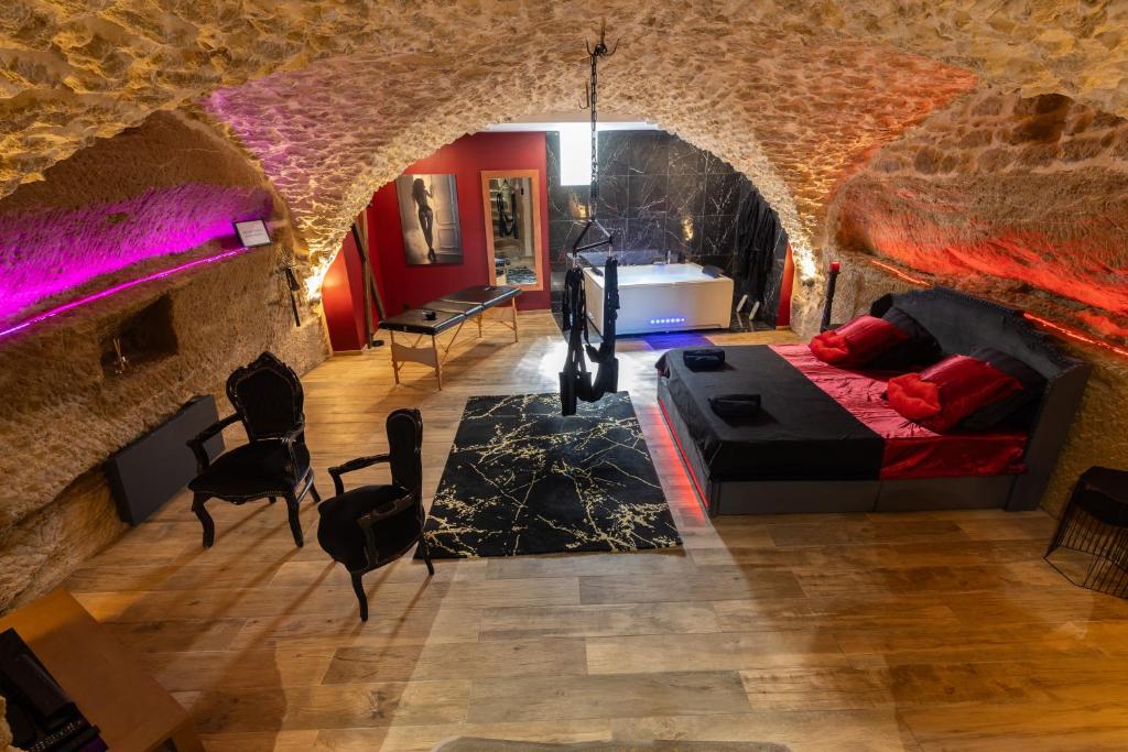 a living room with a bed and a stone wall at l'Envoûtée, suite de charme in Sérignan-du-Comtat