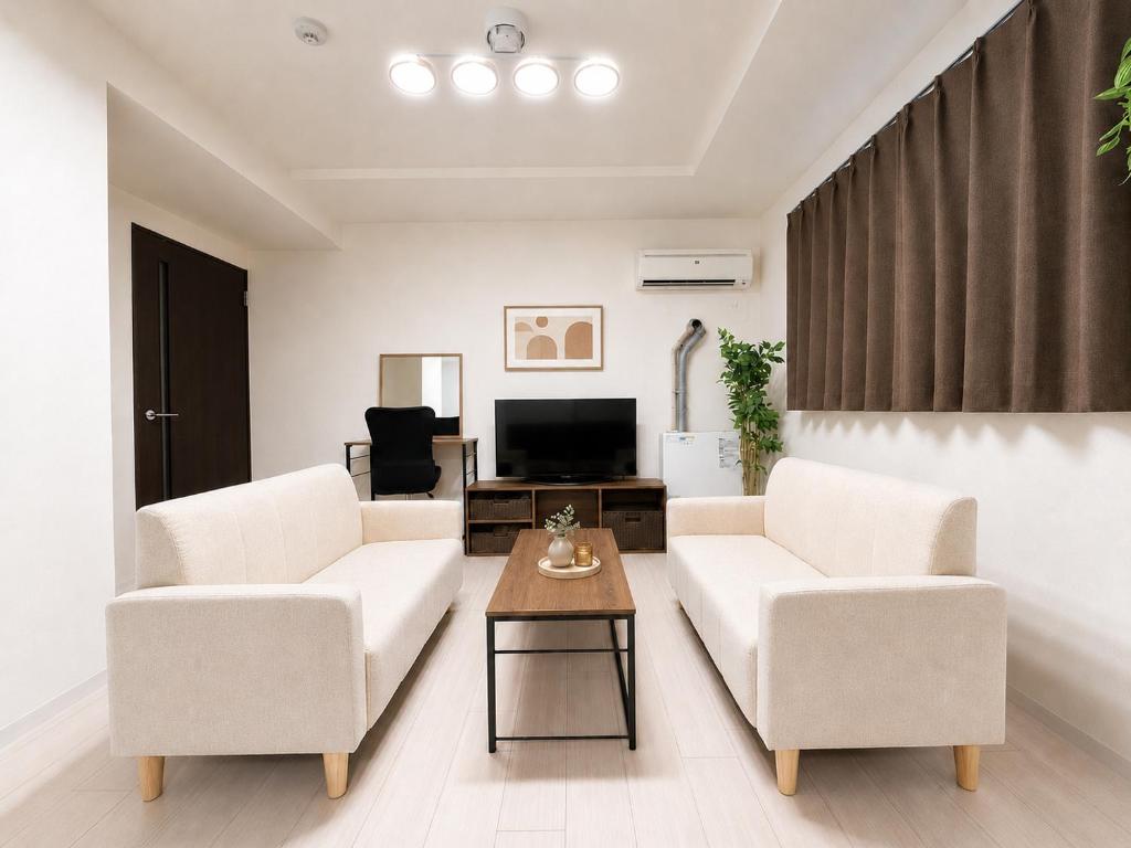 a living room with two white chairs and a table at Excel 琴似 -FIX HOME- in Sapporo
