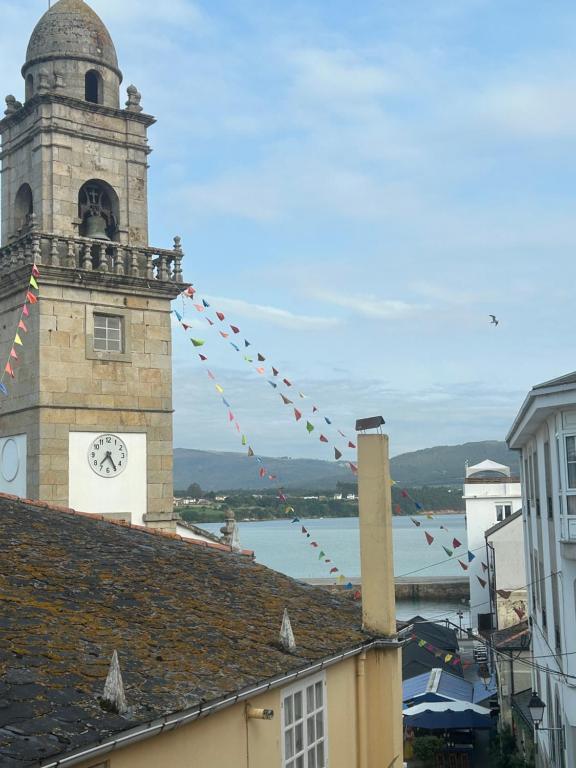 a building with a clock tower with a clock on it at Casa de la plaza in Foz