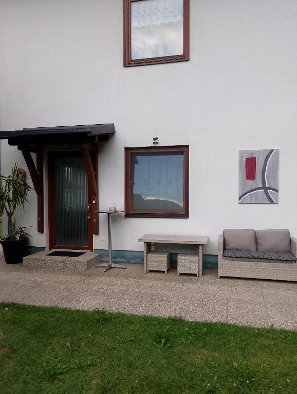a white building with a couch and a table at Haus Steiner in Kleblach