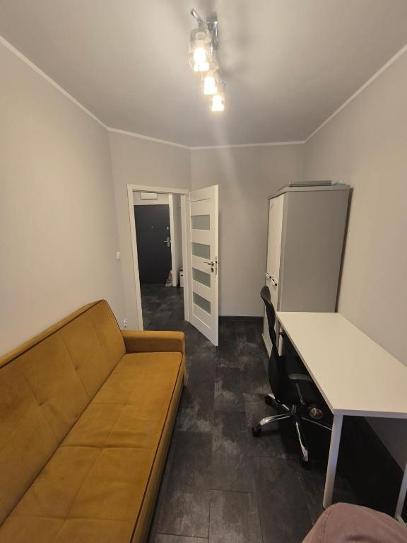 a room with a couch and a desk and a refrigerator at Mieszkanie Fordońska 433A blisko Onkologii in Bydgoszcz