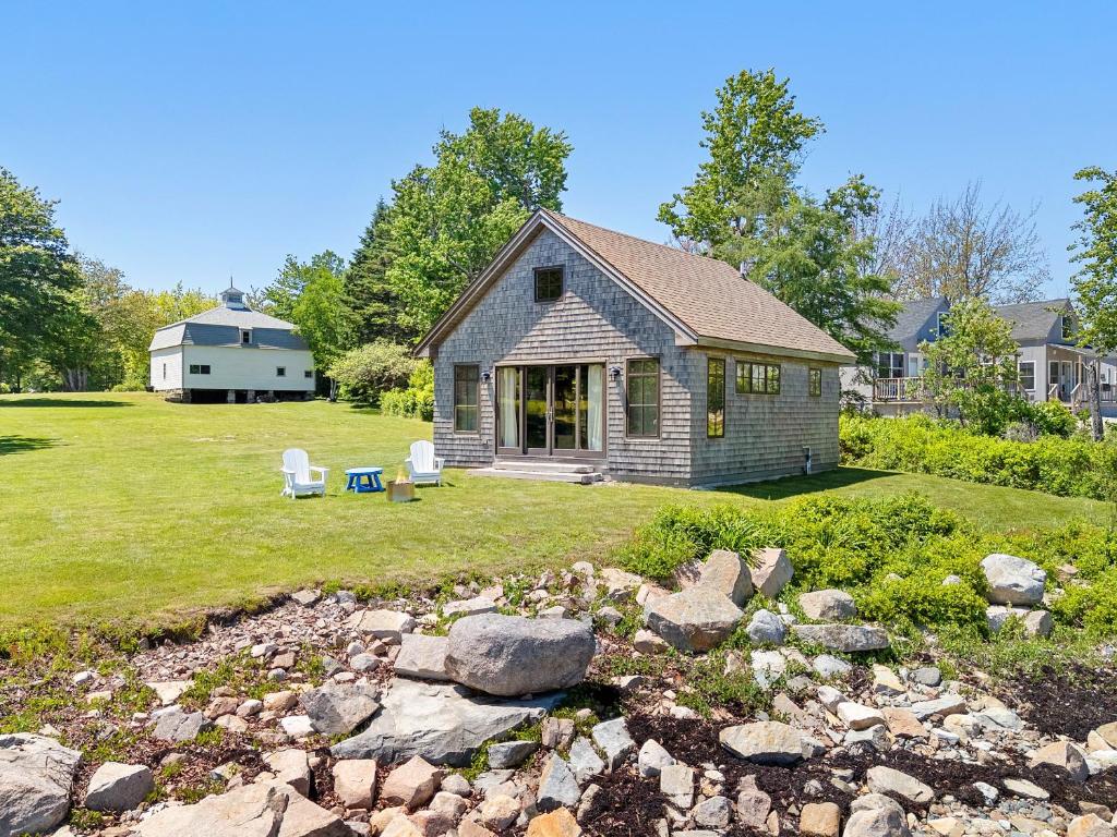 a small house with a yard with rocks at Aril Cottage-Waterfront Escape with Ocean Views in Gouldsboro