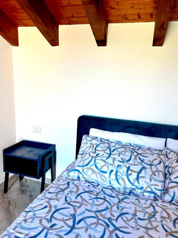 a bedroom with a bed with a nightstand next to it at Agriturismo Yucca in Giustenice