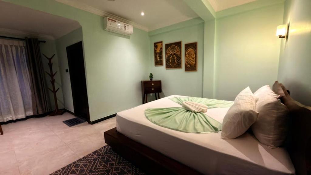 a person laying on a bed in a bedroom at Abbi Holiday - Jaffna Hotel in Jaffna