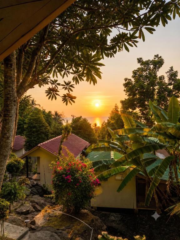 a house with the sunset in the background at Flow Jungle Residency in Haad Yao