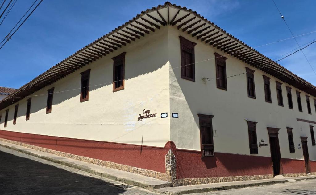 a large white building with windows on a street at Republicano Hostal in Jericó