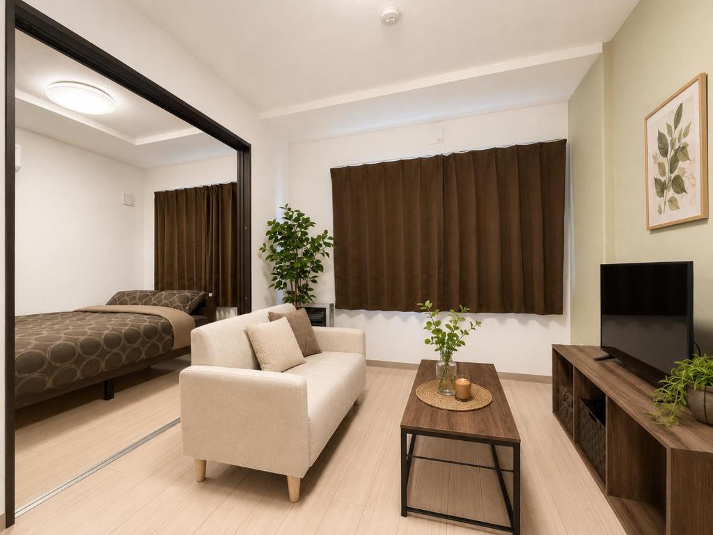 a living room with a couch a chair and a television at Rent菊水 -FIX HOME- in Sapporo