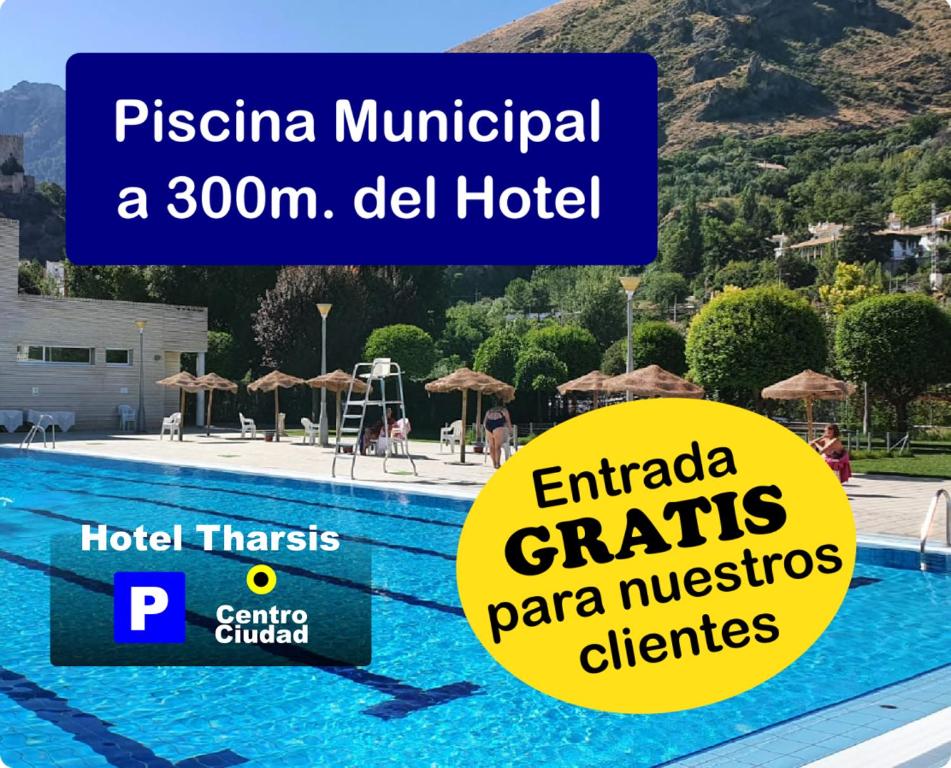 a hotel with a swimming pool with a mountain in the background at Hotel Tharsis in Cazorla