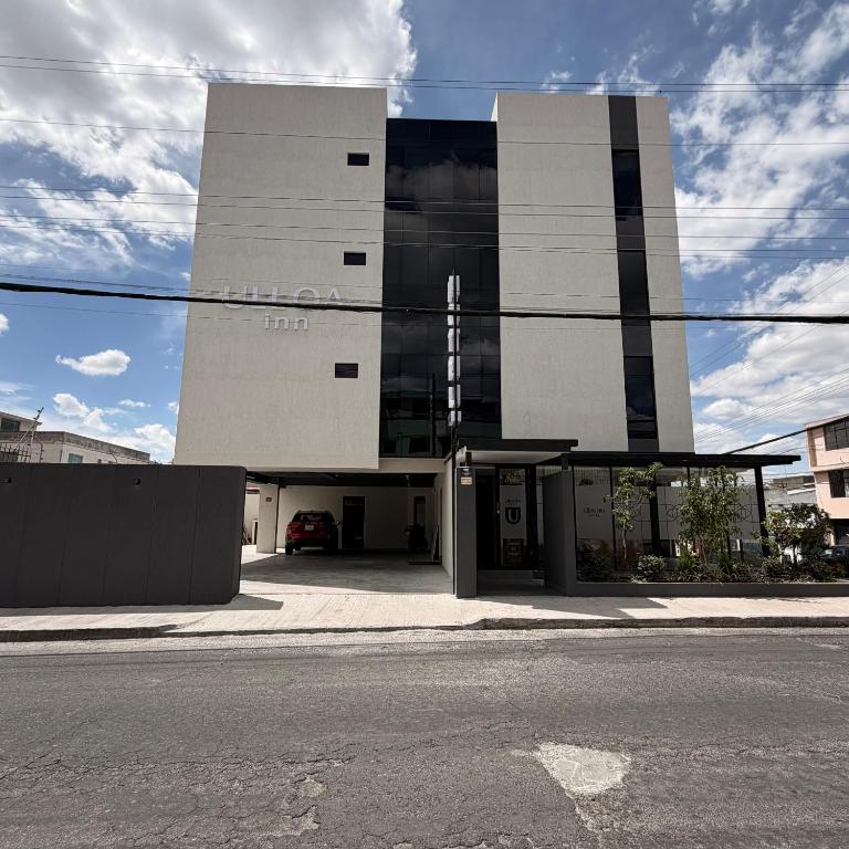 a building on a street with a parking lot at Hotel Ulloa Inn in Quito