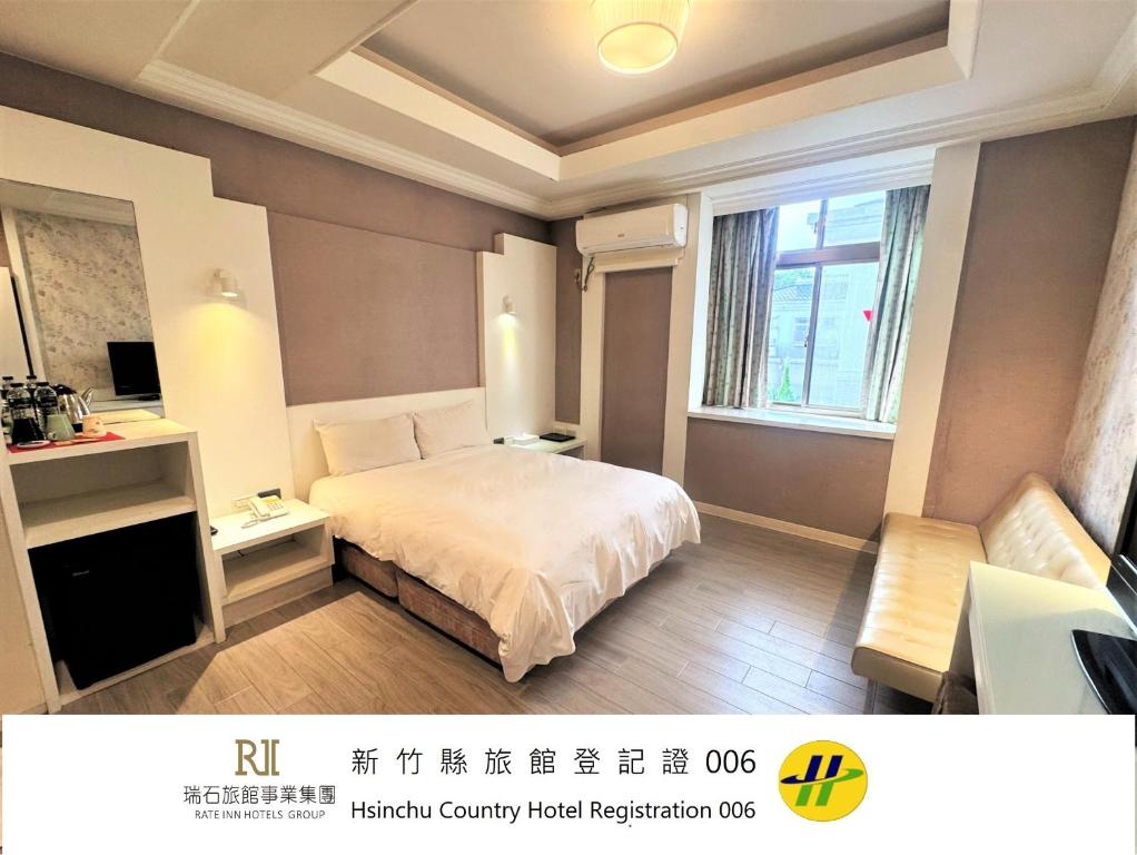 a hotel room with a bed and a window at Guest Motel-Zhubei in Zhubei