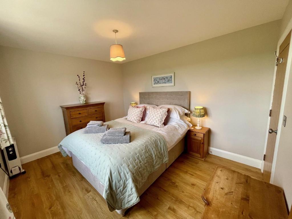 a bedroom with a bed with pillows on it at The Hayloft in Calne