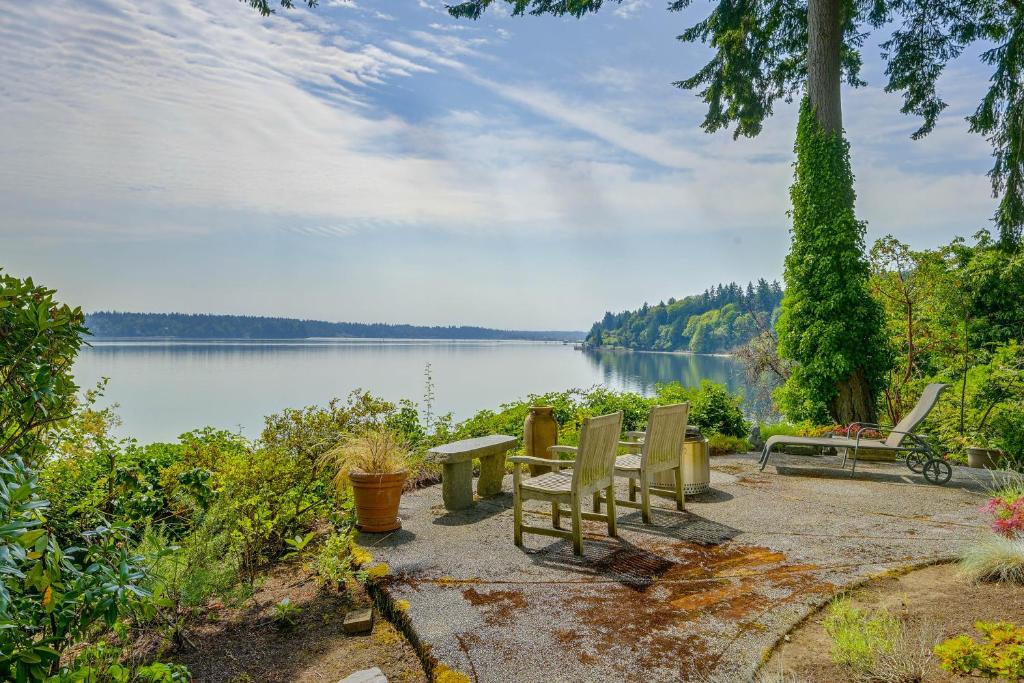 a group of chairs and a table next to a lake at Charming Waterfront Home with Mt Rainier View in Olympia