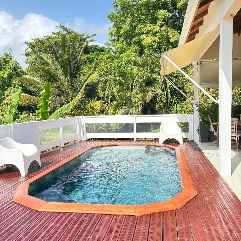 a swimming pool on the deck of a house at La Siguine in Gourbeyre