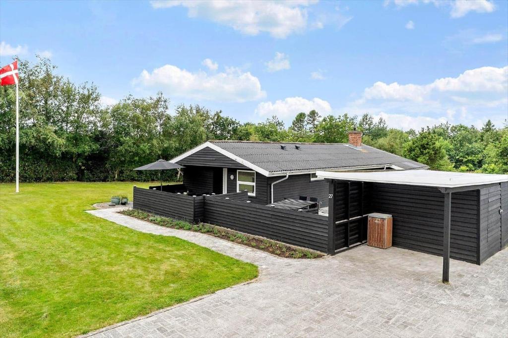 a black house with a gazebo in a yard at LF16127-Logstor-Amandasvej-27 in Trend
