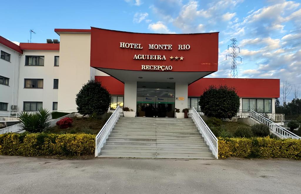 a hotel building with a staircase leading to the entrance at Hotel Monte Rio Aguieira in Almaça