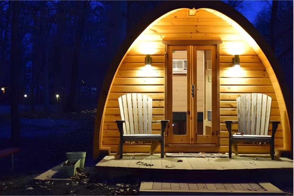 a cabin with two chairs in front of it at Sun Outdoors Yellowstone North in Gardiner