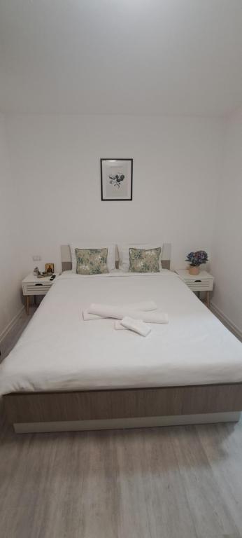 a large bed in a room with two tables at Alex House in Făgăraş