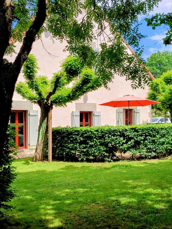 a house with a tree and a red umbrella at Domaine Pouzoult, gîte l'Escalier in Sazeray