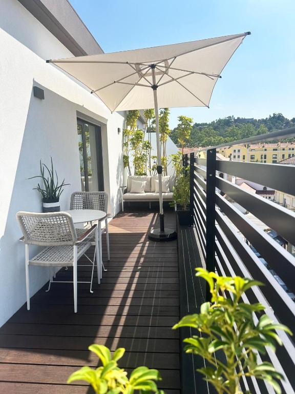 a patio with a table and an umbrella at Leiria Design Suites in Leiria