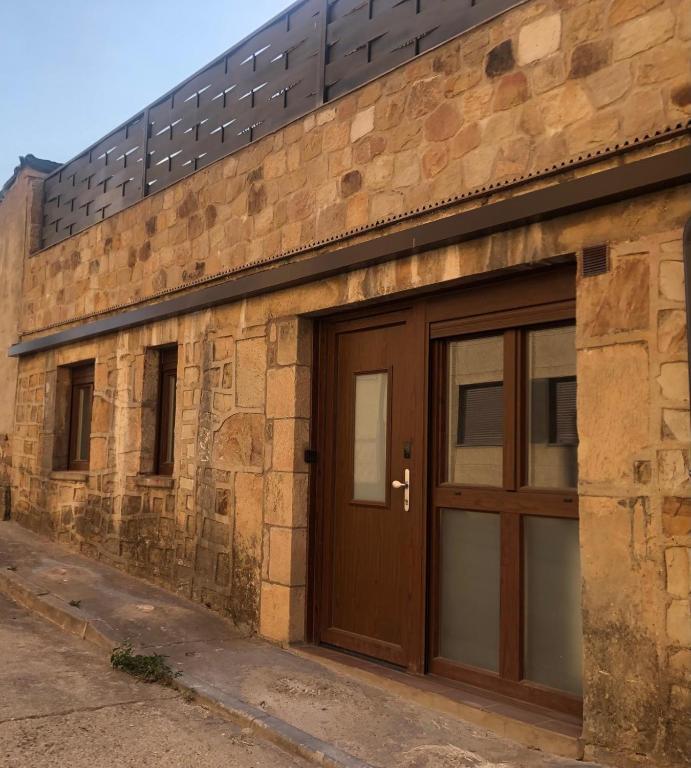a brick building with a wooden garage door at Entre Micelios in Vinuesa