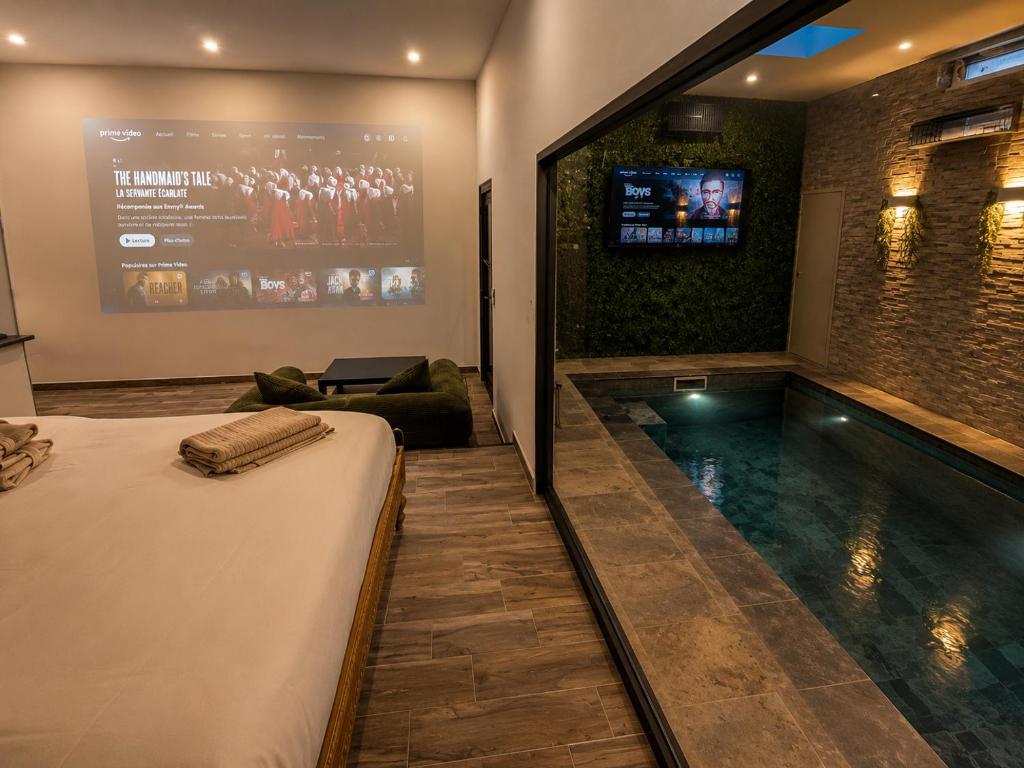 a hotel room with a swimming pool and a tv at Eaux Spa Rive Droite in Rouen