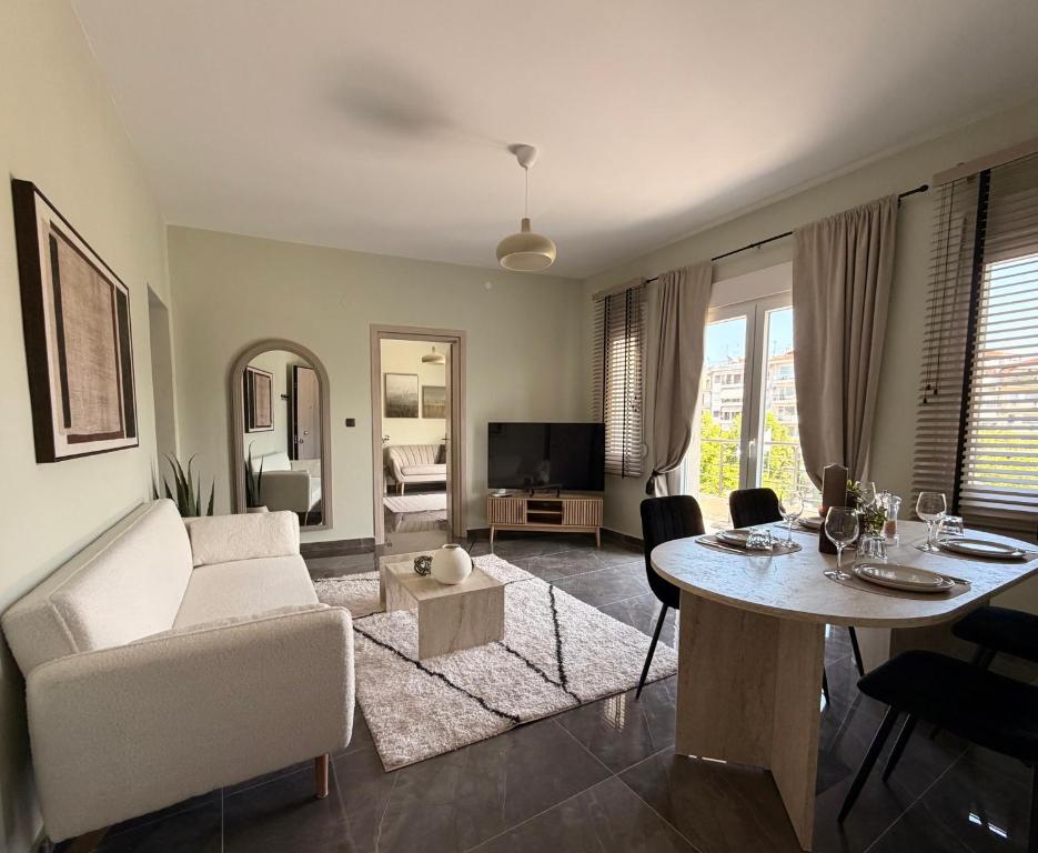 a living room with a white couch and a table at Bistro 49 Luxury suites in Katerini