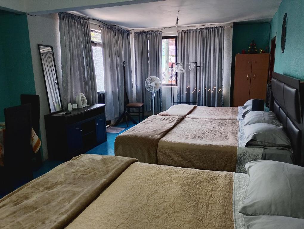 a hotel room with two beds and a window at Hospedaje La Cienega in Zacatlán