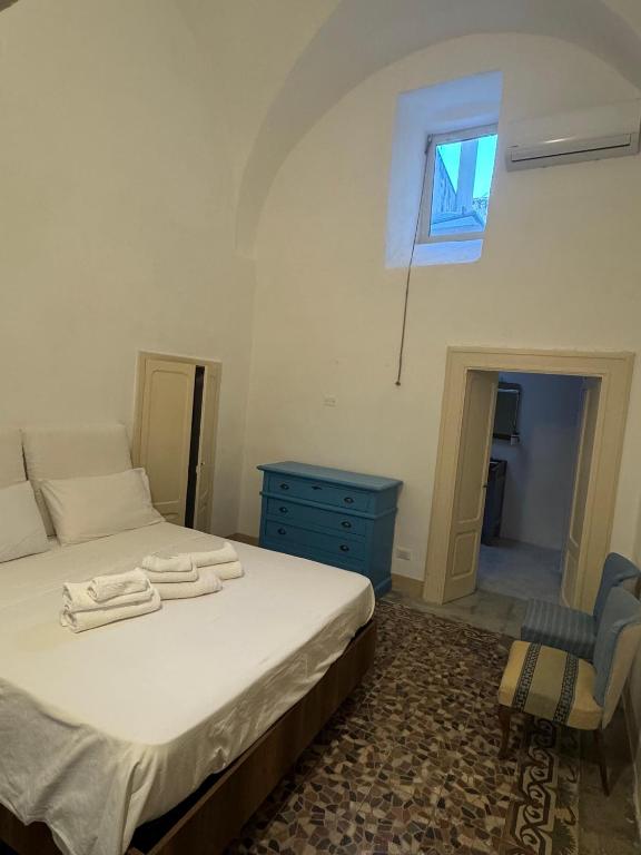 a bedroom with a bed and a blue dresser and a window at Ca Salentu in Galatone