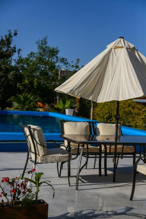 a table and chairs and an umbrella on a patio at Buenas Vibras Hostería Rural in Chicoana