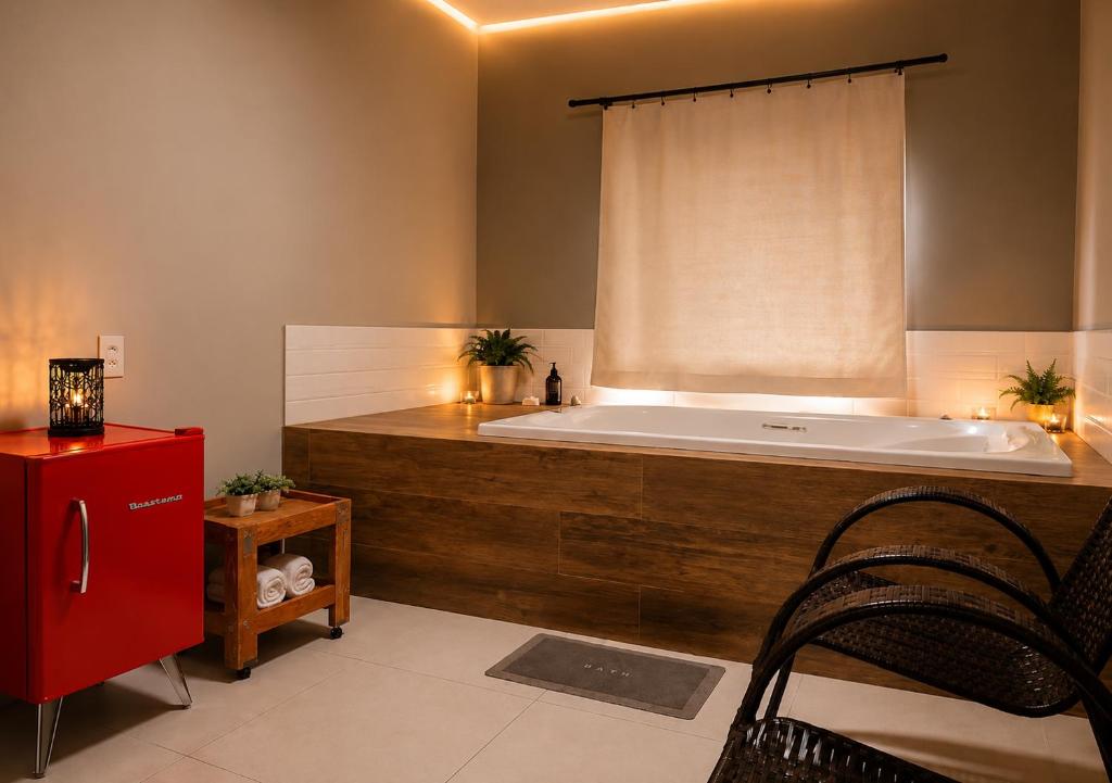 a large bathroom with a large tub with a window at Flat com Jacuzzi em Capitólio - Cantinho do Lago 1 in Capitólio