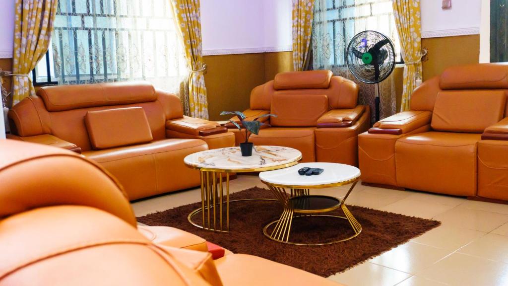 a living room with leather furniture and a table at Jeks Apartments Limited in Ogbunike