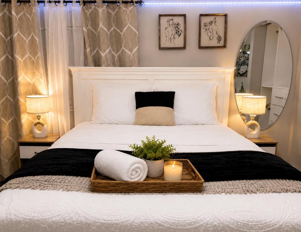 a bedroom with a large bed with two towels and a mirror at Rosa Bella Comfort Suite in Homestead