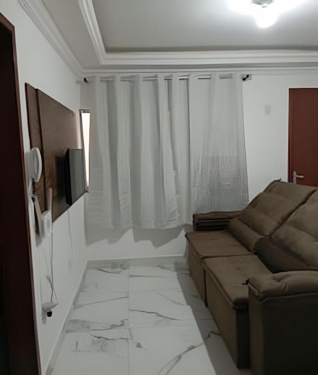 a living room with a couch and a television at Apartamento próximo a Lagoa do Perola in Governador Valadares