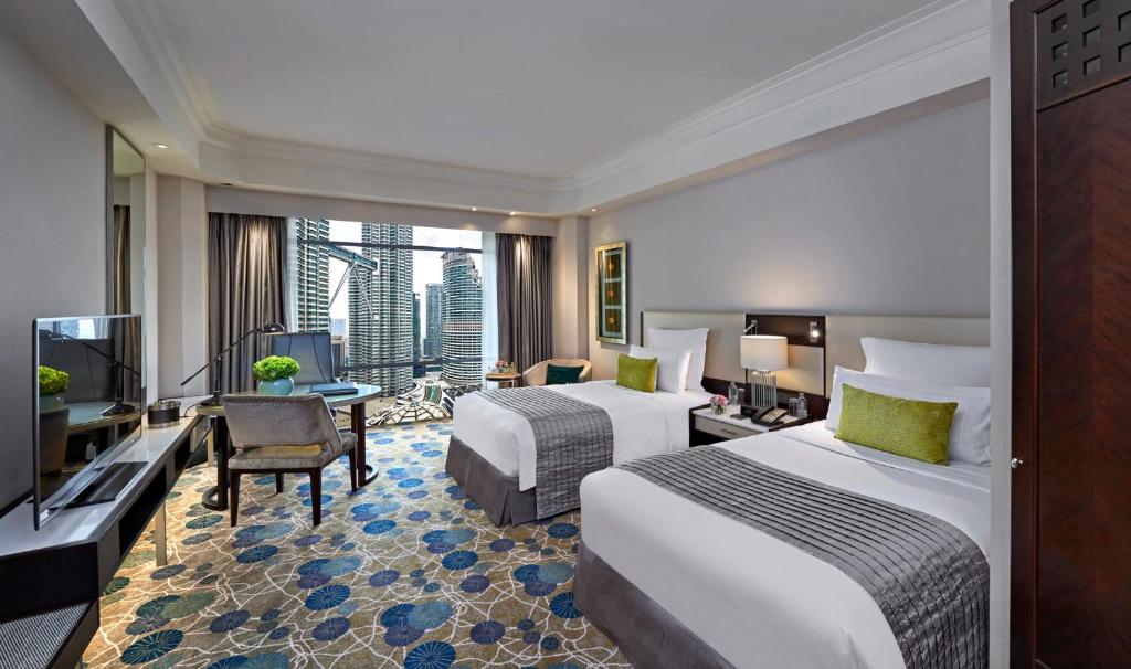 a hotel room with two beds and a television at Mandarin Oriental, Kuala Lumpur in Kuala Lumpur