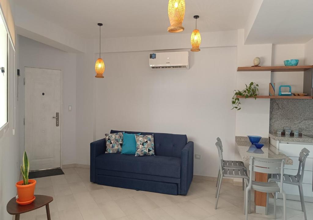 a living room with a blue couch and a table at Yaque Breeze - Beach Apartament in El Yaque