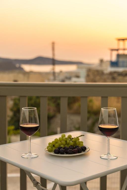 two glasses of wine and a plate of grapes on a table at Astraea in Tripiti