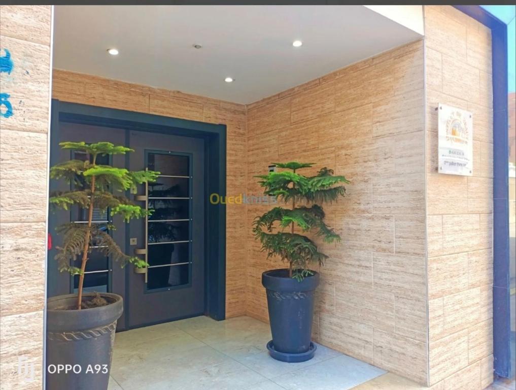a front door of a building with two potted plants at Résidence Luna in Oran