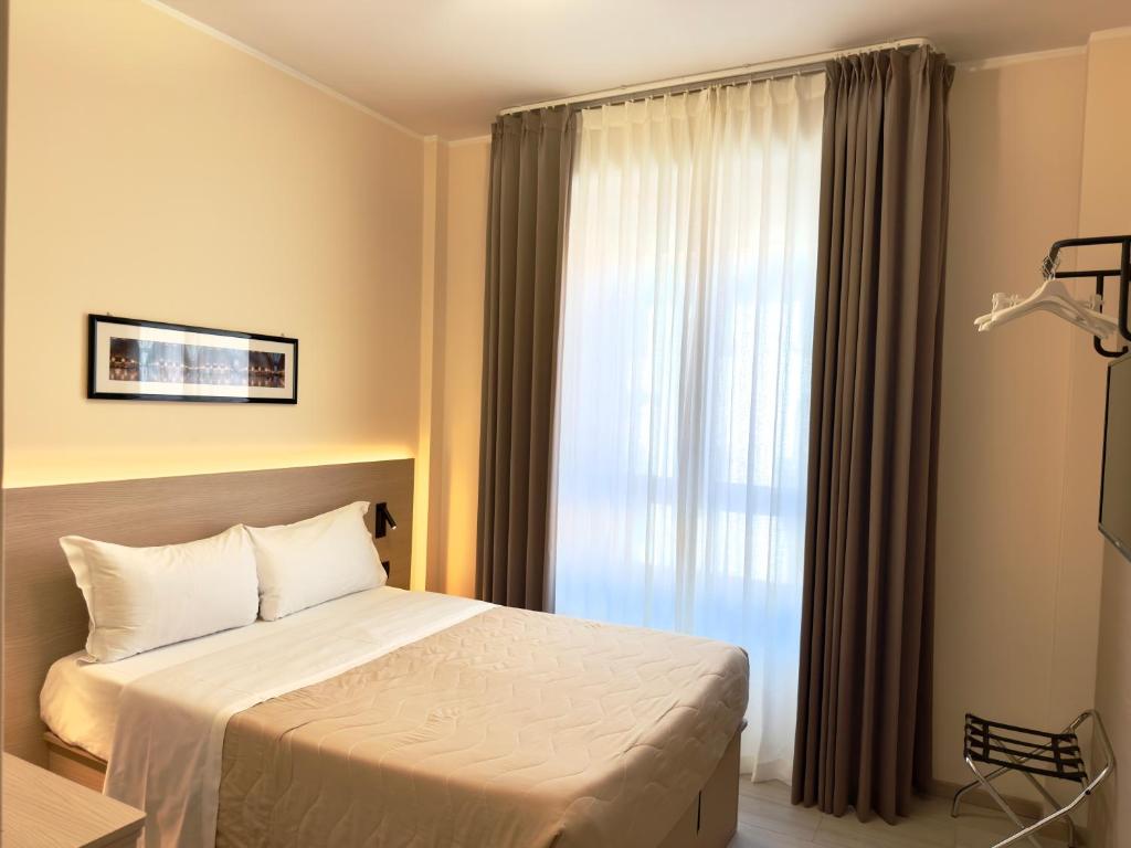 a bedroom with a bed and a large window at Hotel Molise 2 in Milan