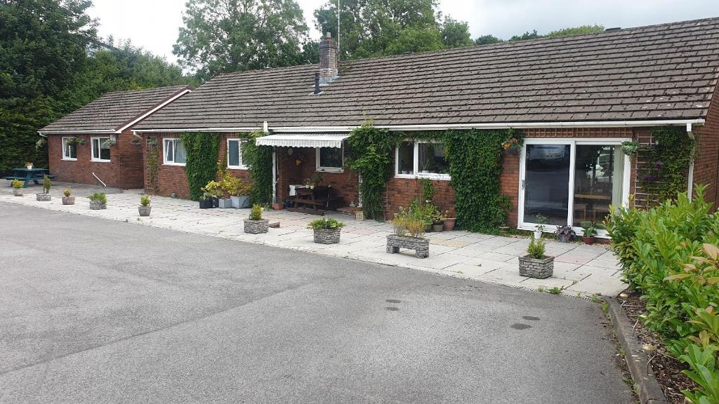 a brick house with potted plants in front of it at Chestnut Lodge Annex in Bridgend